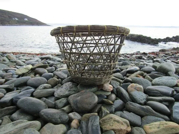 Corbeillle fond catalan et clôture technique de la nasse méditerranéenne sur plage de galet en Bretagne.